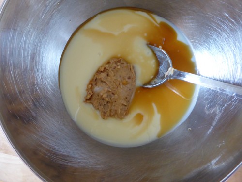 The mix of peanut butter, condensed milk and vanilla extract in a large bowl for the peanut butter ice-cream recipe.